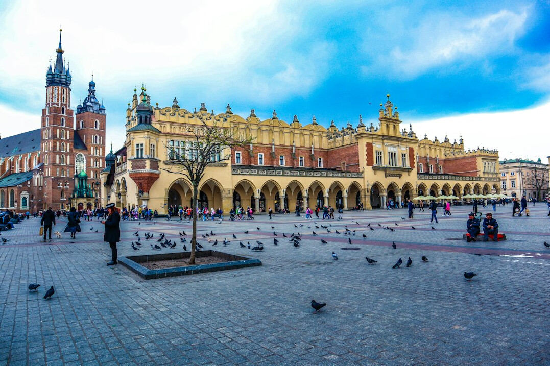 City square with a clock tower in Krakow Poland